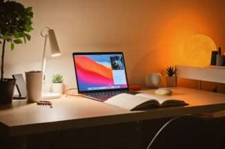 Un bureau éclairé par des lampes de chevet avec un livre ouvert et un ordinateur portable